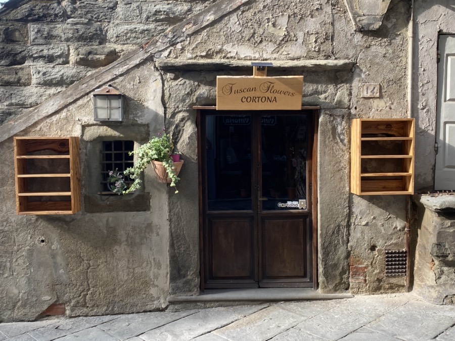 Tuscan Flowers shopfront: Transylvanian oak sign above, olive wood display cabinets beside the door